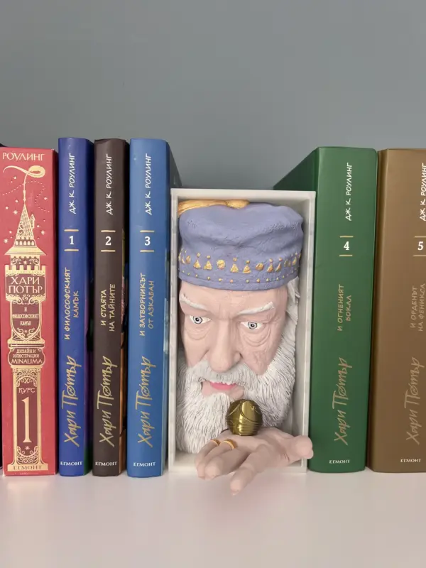 Фронтален изглед на 3D принтиран Book Nook с лице на Албус Дъмбълдор и ръка, която държи Златния Снитч
